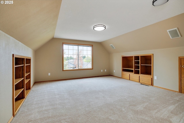 additional living space featuring carpet floors, built in features, baseboards, and vaulted ceiling