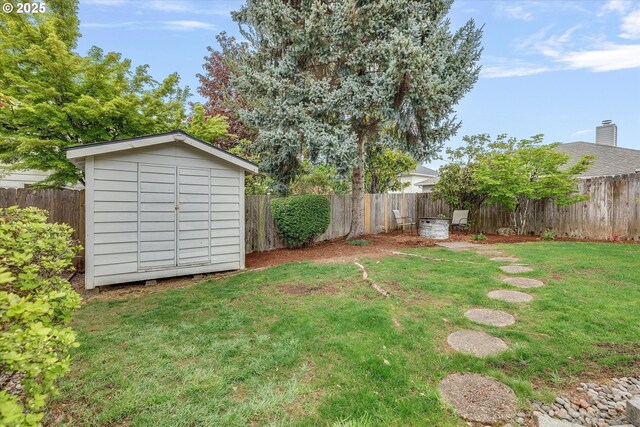 view of yard with a storage shed, an outdoor structure, and a fenced backyard