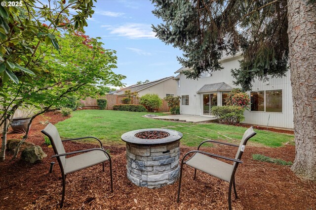 view of yard with fence, a fire pit, and a patio area