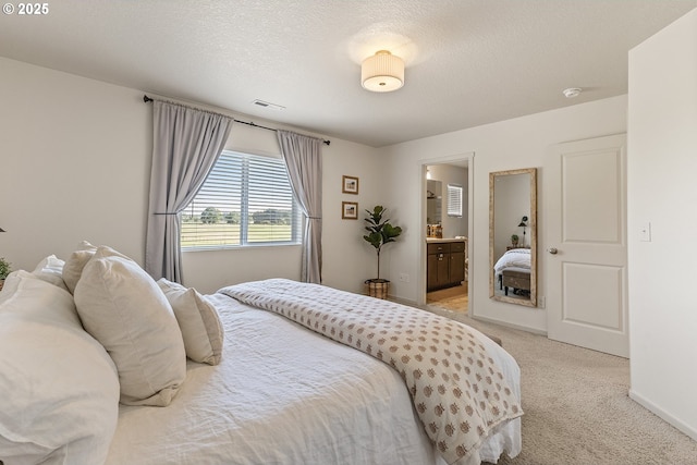 12810 NE 118th Way, Vancouver, WA 98682 - bedroom featuring light carpet, connected bathroom, a textured ceiling, and baseboards