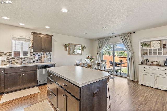12810 NE 118th Way, Vancouver, WA 98682 - kitchen with stainless steel dishwasher, a sink, a kitchen breakfast bar, a textured ceiling, and dark brown cabinets