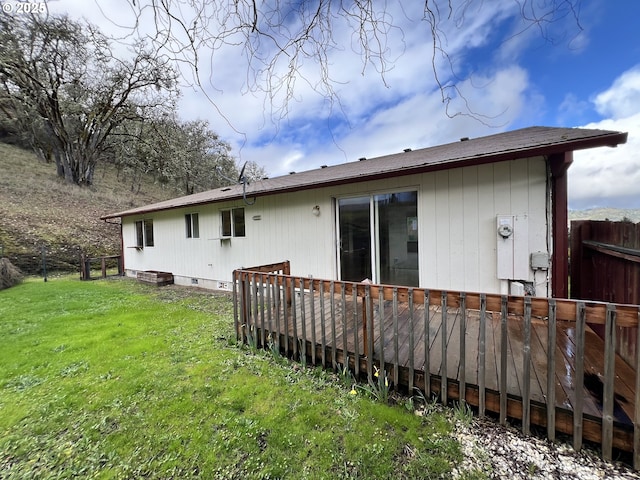 back of house with a deck, crawl space, a lawn, and fence