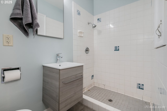 bathroom featuring a tile shower and vanity