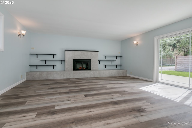 unfurnished living room with light hardwood / wood-style floors and a tile fireplace