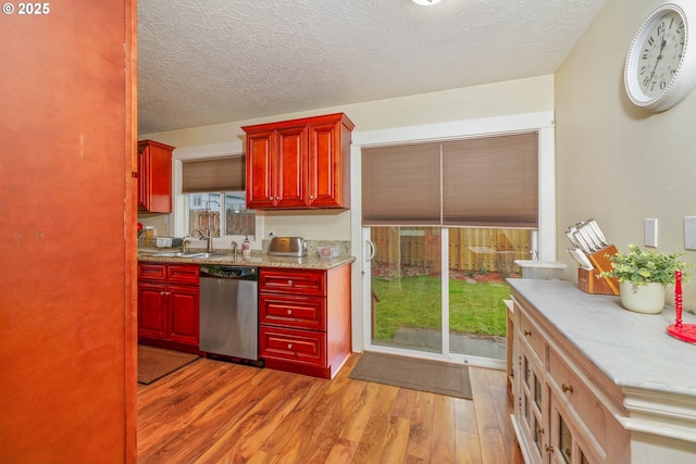 kitchen with dishwasher, light wood-style flooring, light countertops, a textured ceiling, and dark brown cabinets