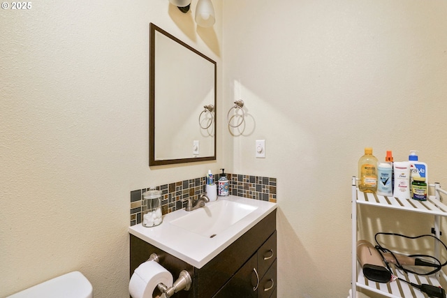 bathroom with toilet, tasteful backsplash, and vanity