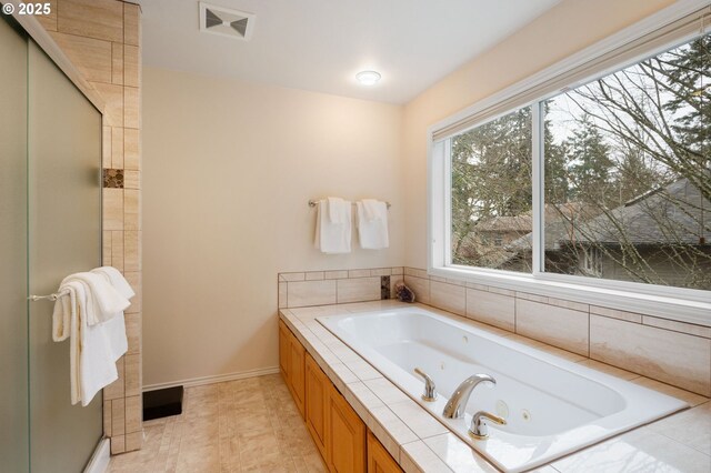 bathroom featuring a skylight, a bathtub, and vanity