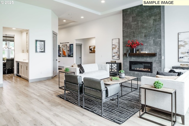 28006 NE 168th Ave, Battle Ground, WA 98604 - living area featuring beverage cooler, a towering ceiling, light wood-type flooring, a fireplace, and recessed lighting