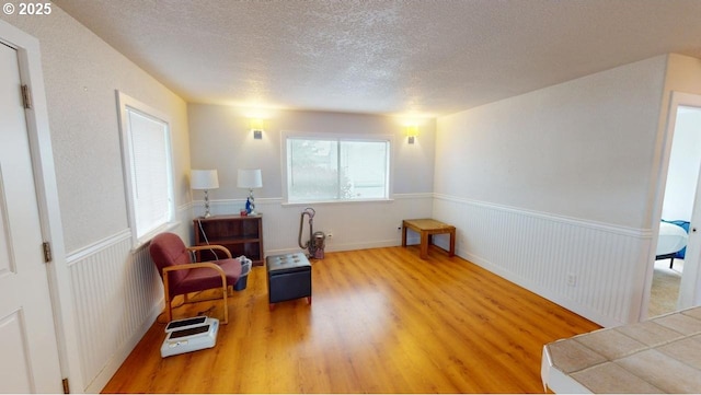 94237 6th St, Gold Beach, OR 97444 - sitting room with wood finished floors, a textured ceiling, and wainscoting
