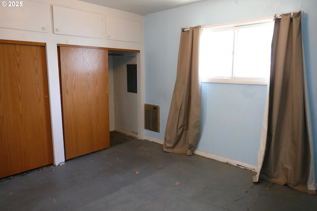 unfurnished bedroom with heating unit and two closets