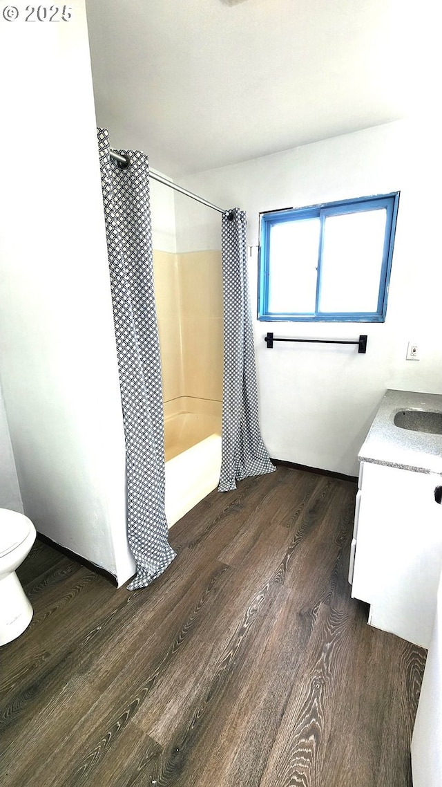 full bathroom featuring shower / tub combo with curtain, vanity, hardwood / wood-style flooring, and toilet