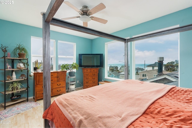 3158 SW Beach Ave, Lincoln City, OR 97367 - bedroom featuring multiple windows, wood finished floors, access to outside, and a ceiling fan