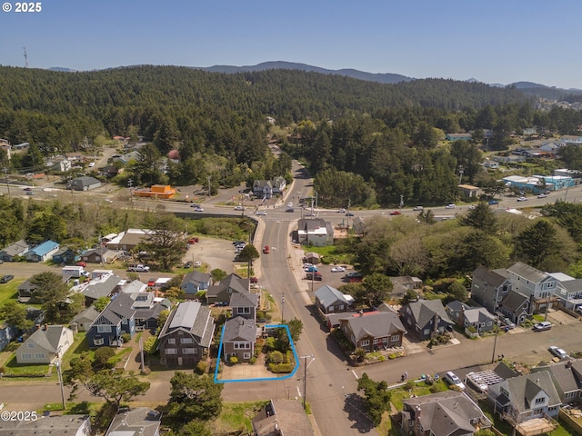 3158 SW Beach Ave, Lincoln City, OR 97367 - aerial view of residential area featuring a heavily wooded area, property boundaries highlighted, and a mountainous background