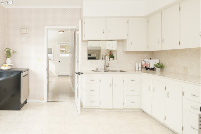 kitchen with light countertops, light floors, a sink, and wallpapered walls