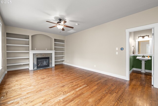 13243 SE Buford Ct, Portland, OR 97236 - unfurnished living room featuring a ceiling fan, built in features, a tile fireplace, wood finished floors, and baseboards