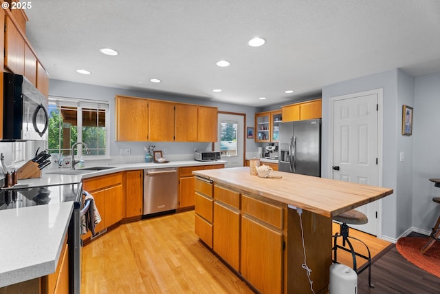 3218 SW Corbeth Ln, Troutdale, OR 97060 - kitchen featuring stainless steel appliances, a sink, light wood-style floors, a kitchen island, and recessed lighting
