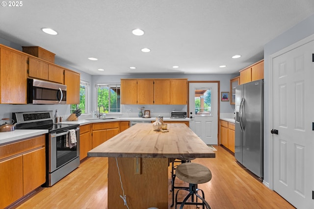 3218 SW Corbeth Ln, Troutdale, OR 97060 - kitchen with appliances with stainless steel finishes, a sink, plenty of natural light, a kitchen breakfast bar, and recessed lighting