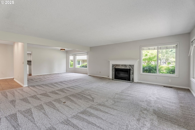 8085 SW Fairway Dr, Wilsonville, OR 97070 - unfurnished living room featuring a textured ceiling, carpet flooring, and a high end fireplace