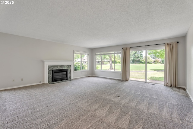8085 SW Fairway Dr, Wilsonville, OR 97070 - unfurnished living room featuring a textured ceiling, carpet floors, plenty of natural light, and a fireplace