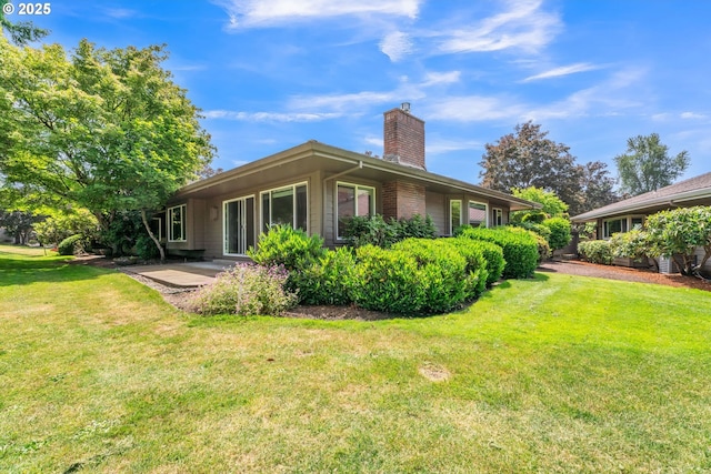 8085 SW Fairway Dr, Wilsonville, OR 97070 - back of house featuring a chimney, a lawn, and a patio area