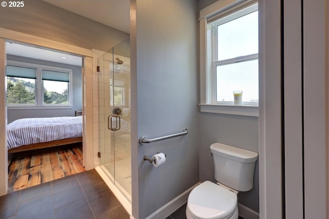 full bathroom featuring plenty of natural light, a stall shower, and toilet