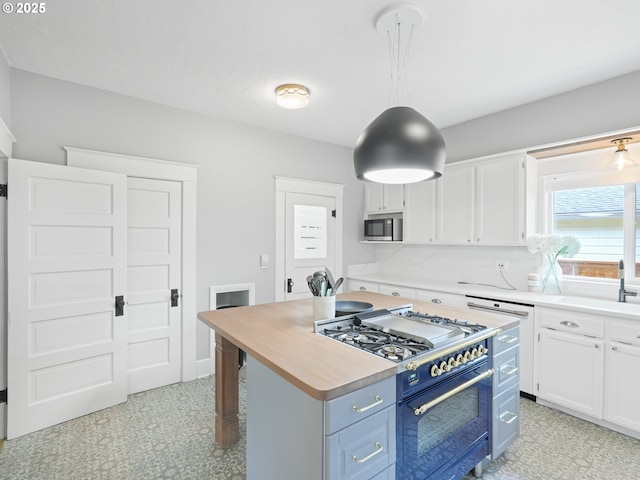 3327 4th St, Hubbard, OR 97032 - kitchen featuring double oven range, light floors, white cabinets, and stainless steel microwave