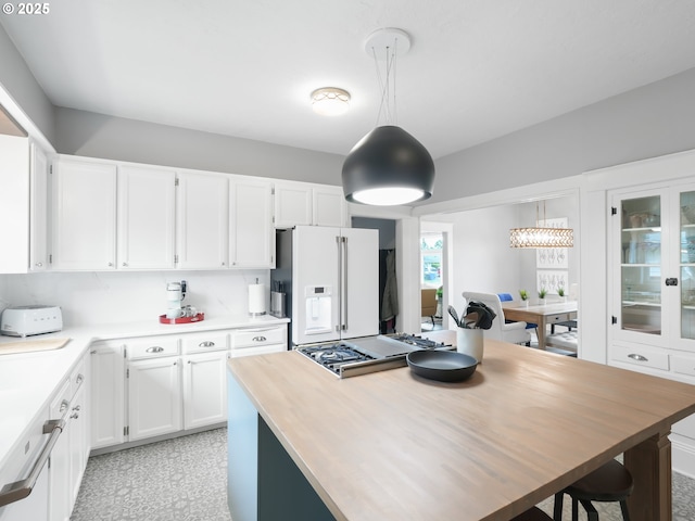 3327 4th St, Hubbard, OR 97032 - kitchen with white fridge with ice dispenser, white cabinetry, pendant lighting, and a center island