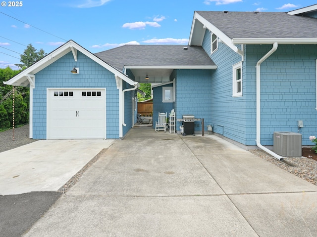 3327 4th St, Hubbard, OR 97032 - view of front facade featuring central air condition unit, a shingled roof, driveway, an attached garage, and an outbuilding