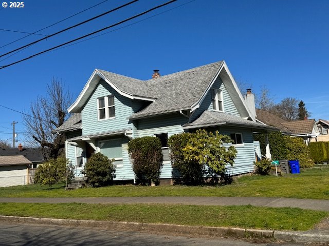 view of side of home with a yard and a chimney