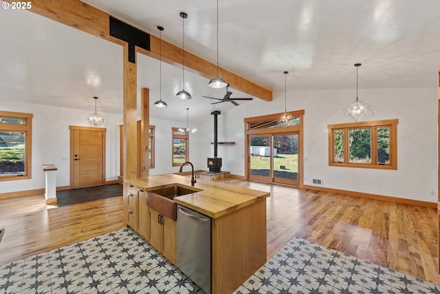 kitchen with vaulted ceiling with beams, visible vents, stainless steel dishwasher, open floor plan, and a sink