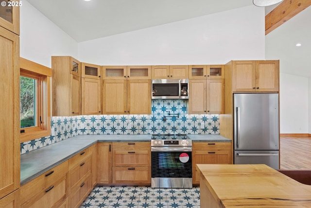 kitchen with light floors, appliances with stainless steel finishes, backsplash, and glass insert cabinets