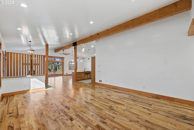 unfurnished living room featuring vaulted ceiling with beams, recessed lighting, wood finished floors, and baseboards