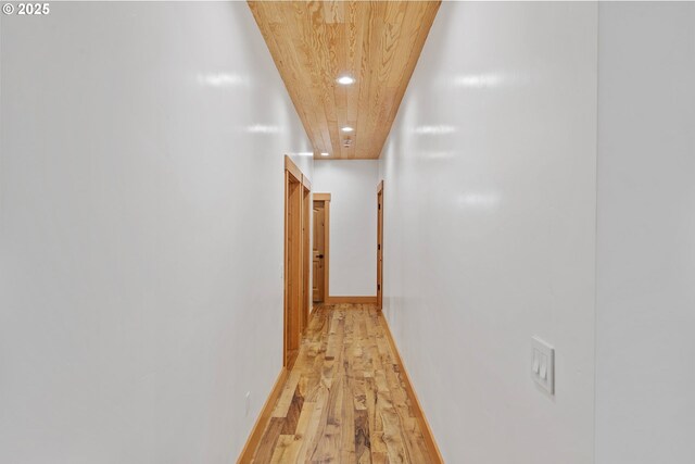 hallway with baseboards, recessed lighting, wooden ceiling, and light wood-style floors