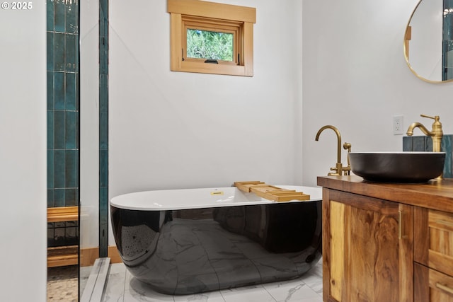 full bath featuring a freestanding bath, marble finish floor, and vanity