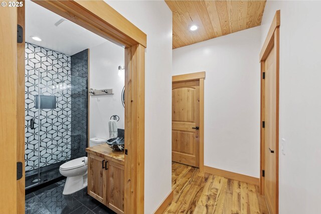 full bath featuring tiled shower, toilet, wood ceiling, vanity, and recessed lighting