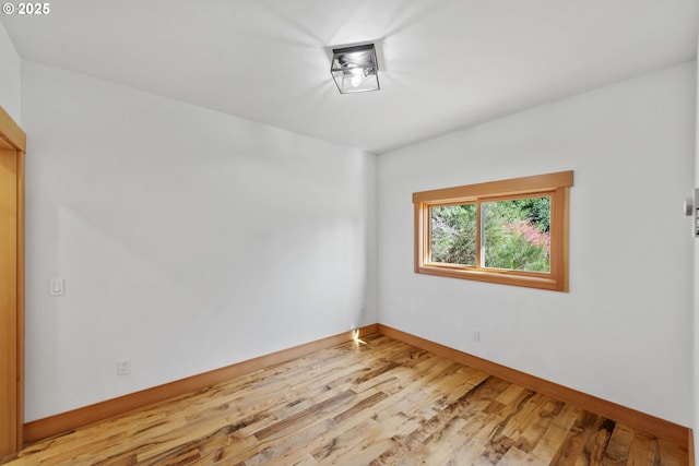 empty room featuring wood finished floors and baseboards