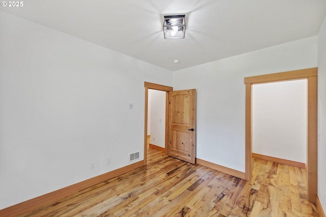 interior space with light wood finished floors, visible vents, and baseboards