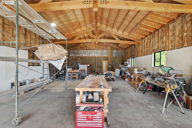 misc room featuring vaulted ceiling, a workshop area, and concrete floors