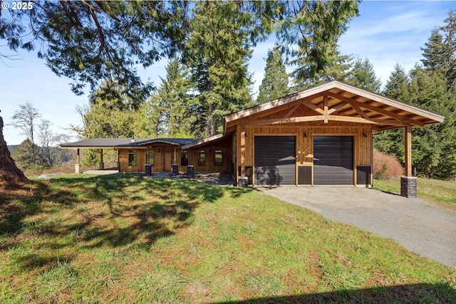 view of front of property featuring a front yard, driveway, and an attached garage