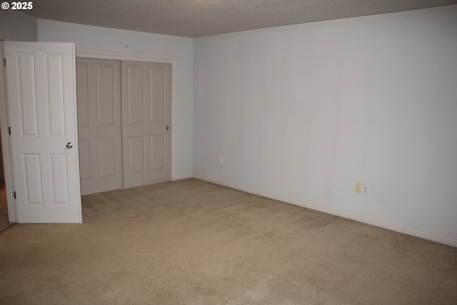 unfurnished bedroom with light carpet, a closet, and a textured ceiling