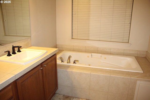 bathroom featuring vanity and tiled bath