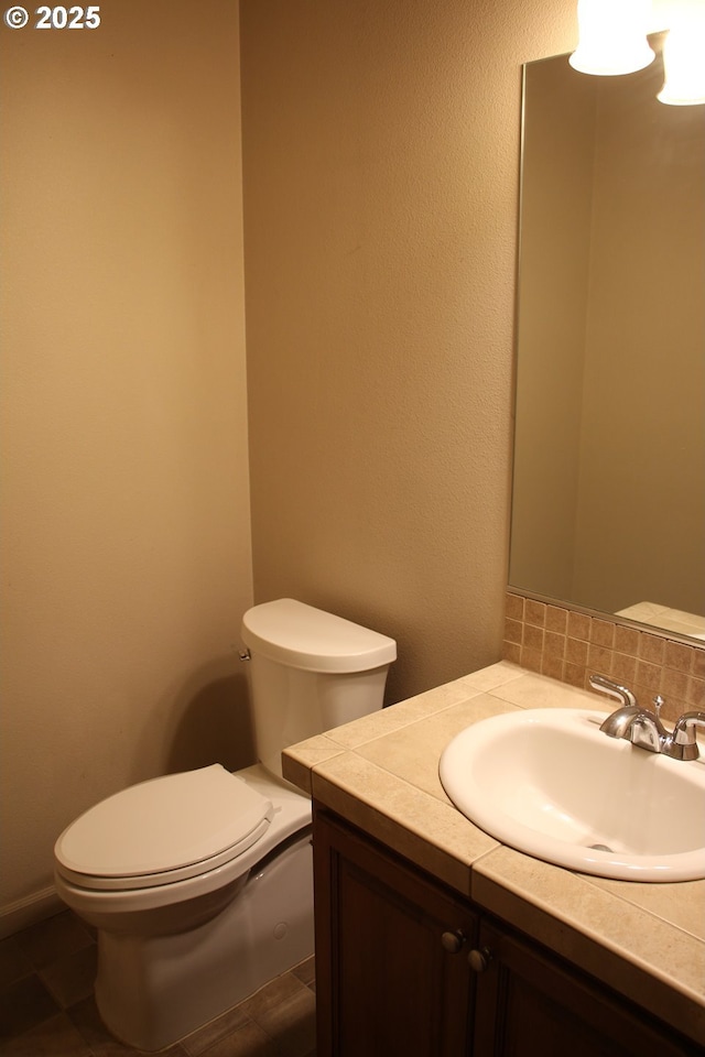 bathroom featuring tasteful backsplash, vanity, and toilet