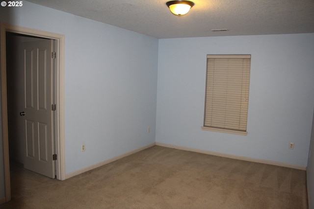 empty room featuring a textured ceiling and carpet