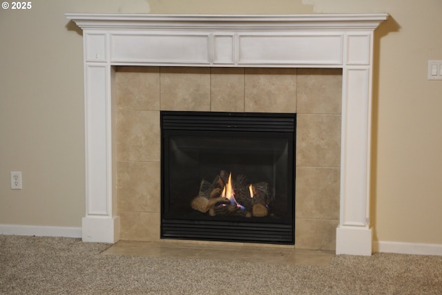 details with a tile fireplace and carpet flooring