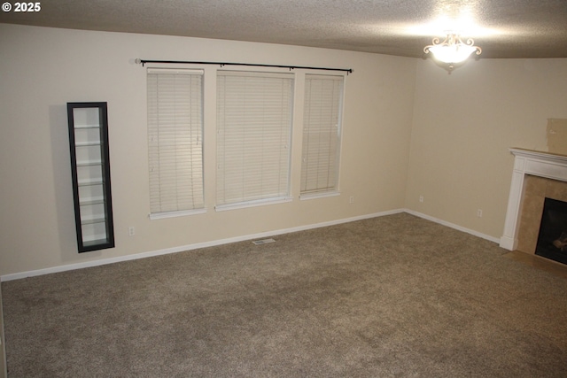 unfurnished living room featuring carpet, a textured ceiling, and a fireplace