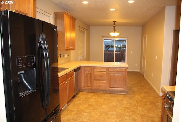 kitchen featuring pendant lighting, stainless steel appliances, kitchen peninsula, and a textured ceiling