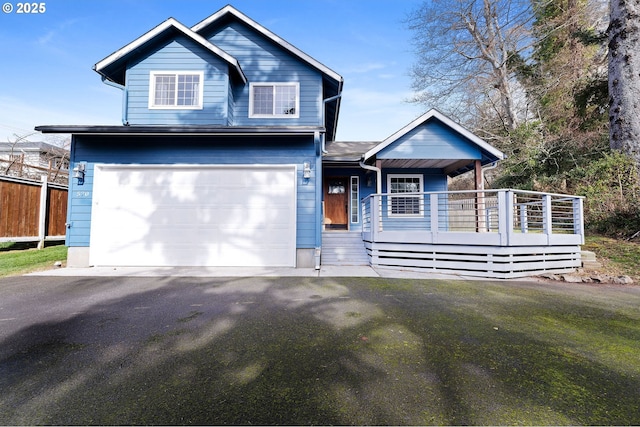 view of front of home featuring driveway, a porch, and fence