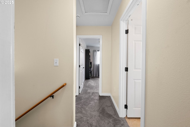 corridor with carpet floors, an upstairs landing, and baseboards