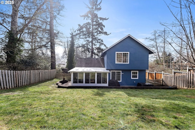 rear view of property featuring a sunroom, a fenced backyard, a yard, and a wooden deck