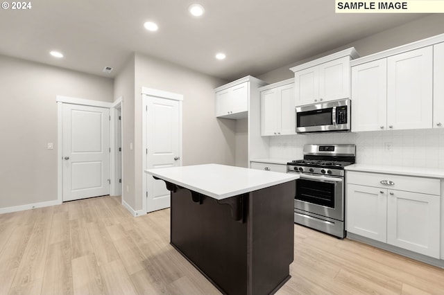 3118 S Magnolia Dr Unit Lt752, Cornelius, OR 97113 - kitchen featuring appliances with stainless steel finishes, a kitchen island, tasteful backsplash, white cabinetry, and light countertops